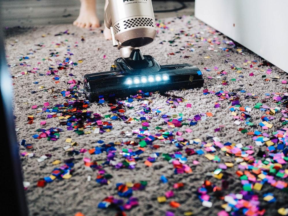 Vacuum Cleaner Being Used To Clean Confetti From Carpet