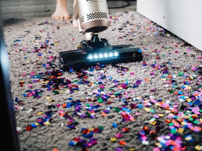 Person Vacuuming The Carpet To Clean Confetti